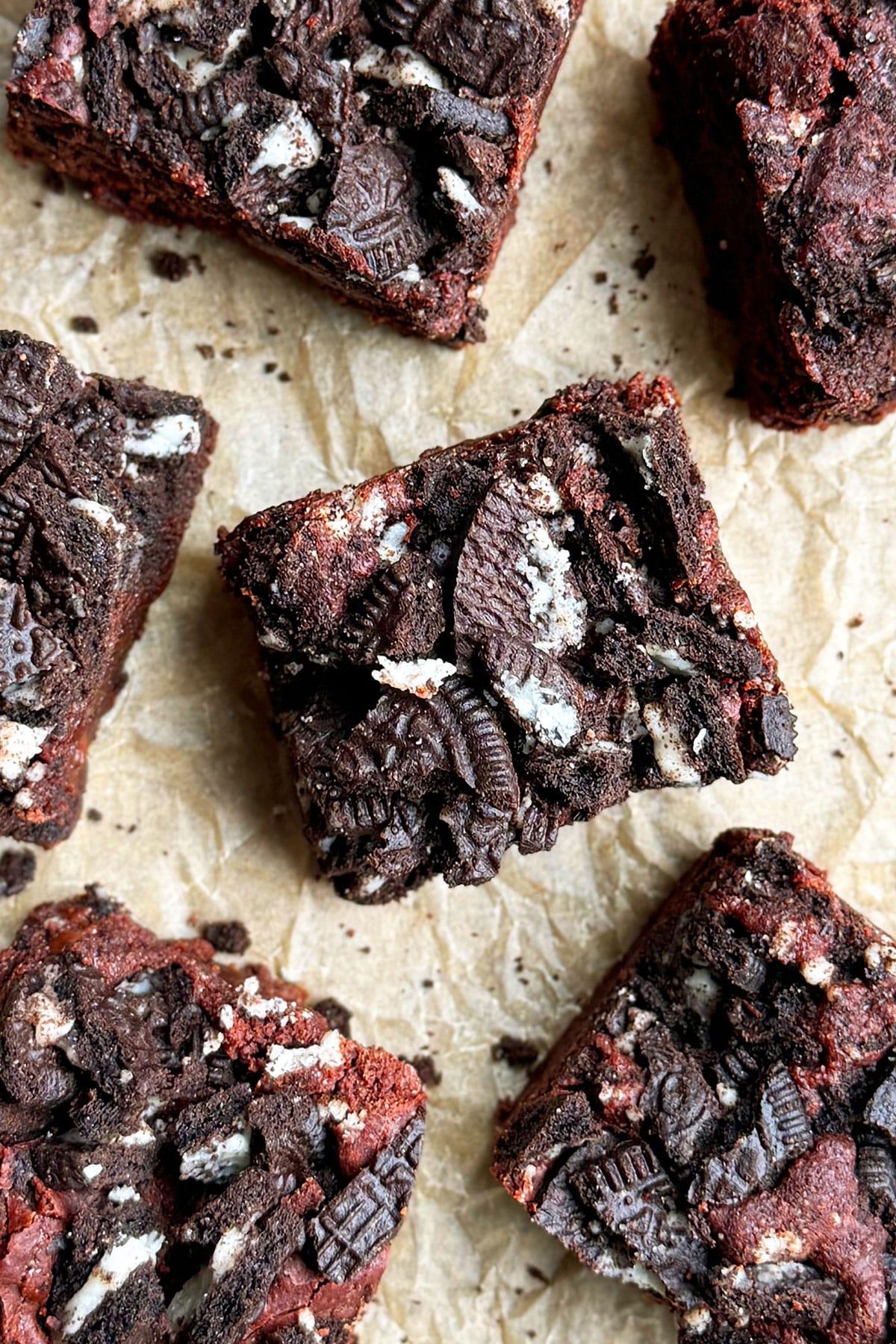 Overhead shot of slices of brownies on brown parchment paper. 