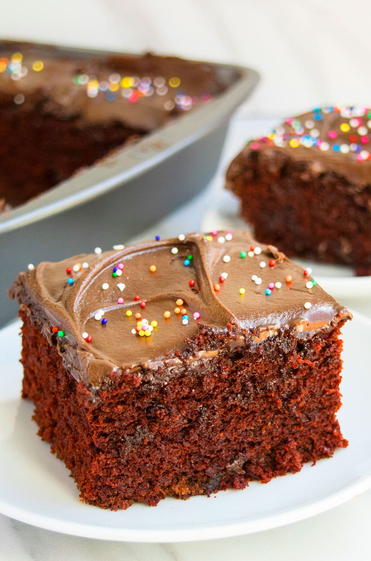 Slice of Wacky Chocolate Depression Cake on White Dish.