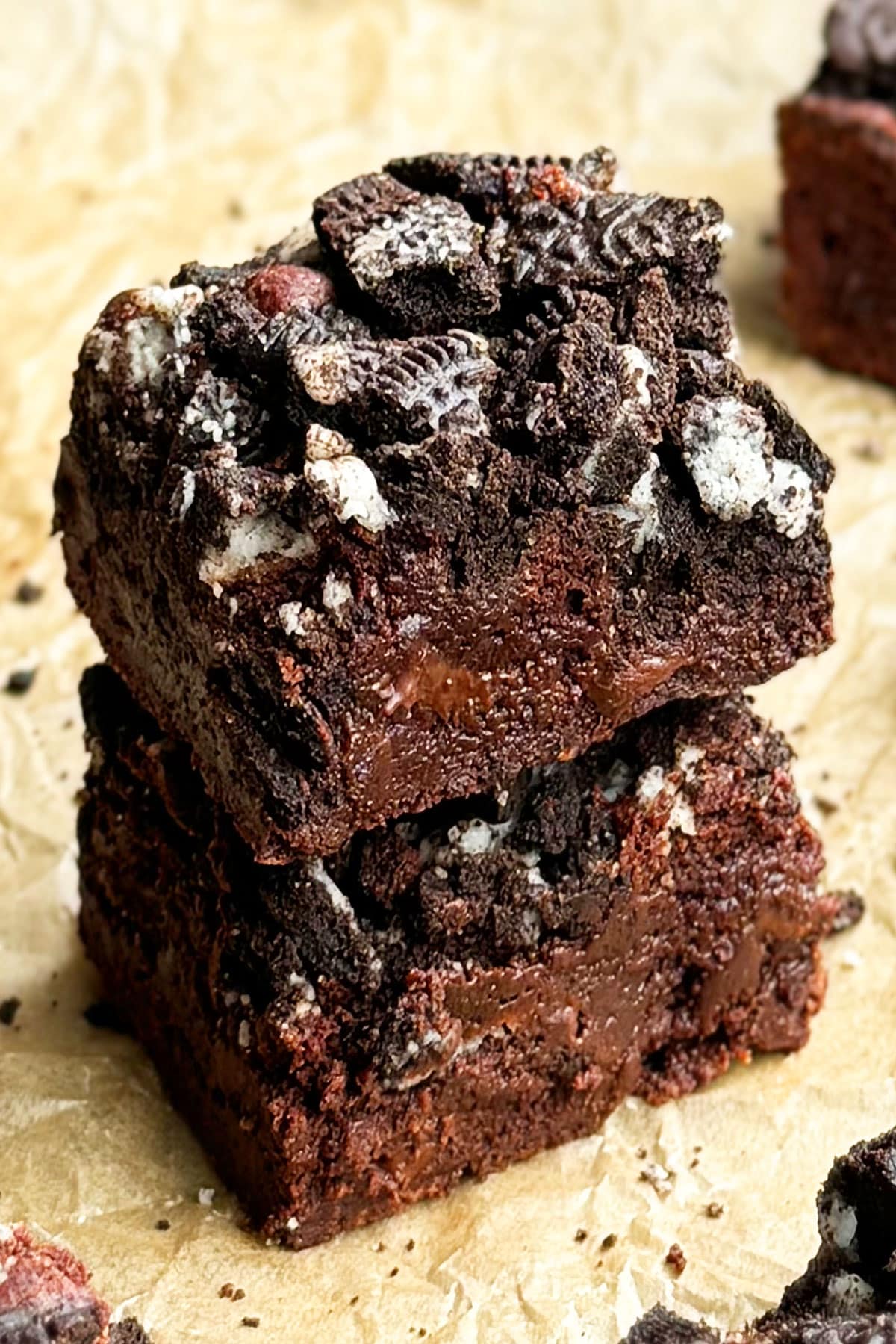 Stack of easy fudgy chocolate Oreo brownies on brown parchment paper.