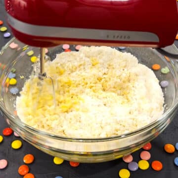 Flour being mixed with the eggs and oil in glass bowl. 