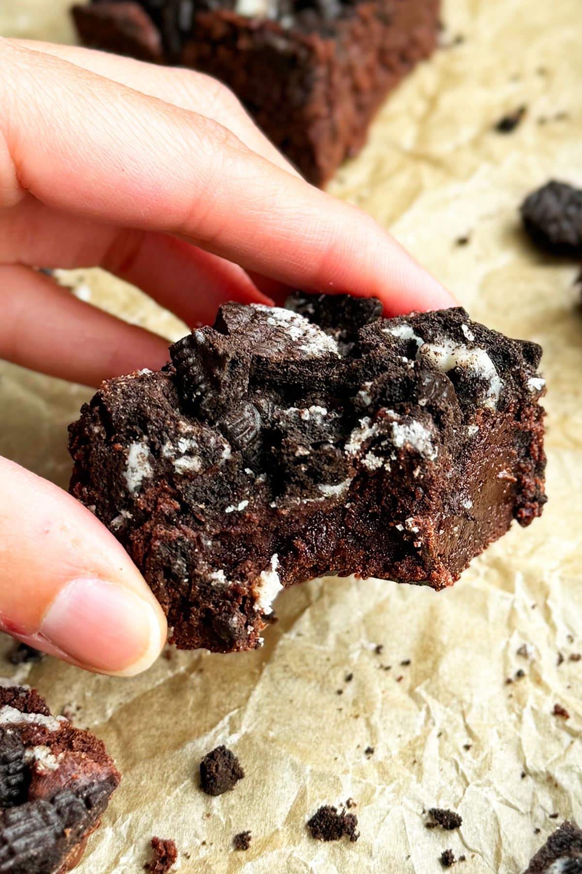 Fingers holding partially eaten brownie- Closeup shot. 