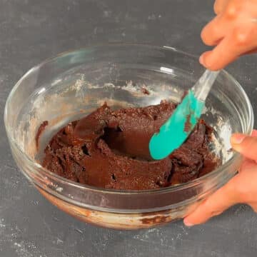 Batter in glass bowl being mixed with a spatula.  