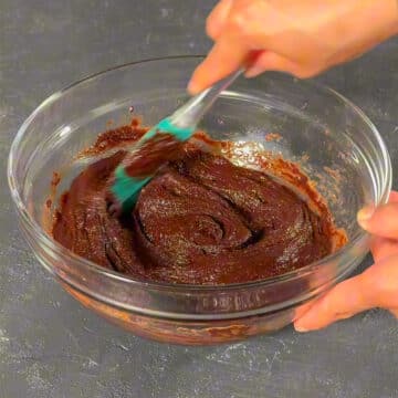 Batter in glass bowl being mixed with a spatula.