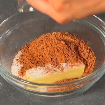 Large glass bowl with butter, sugar and cocoa powder. 