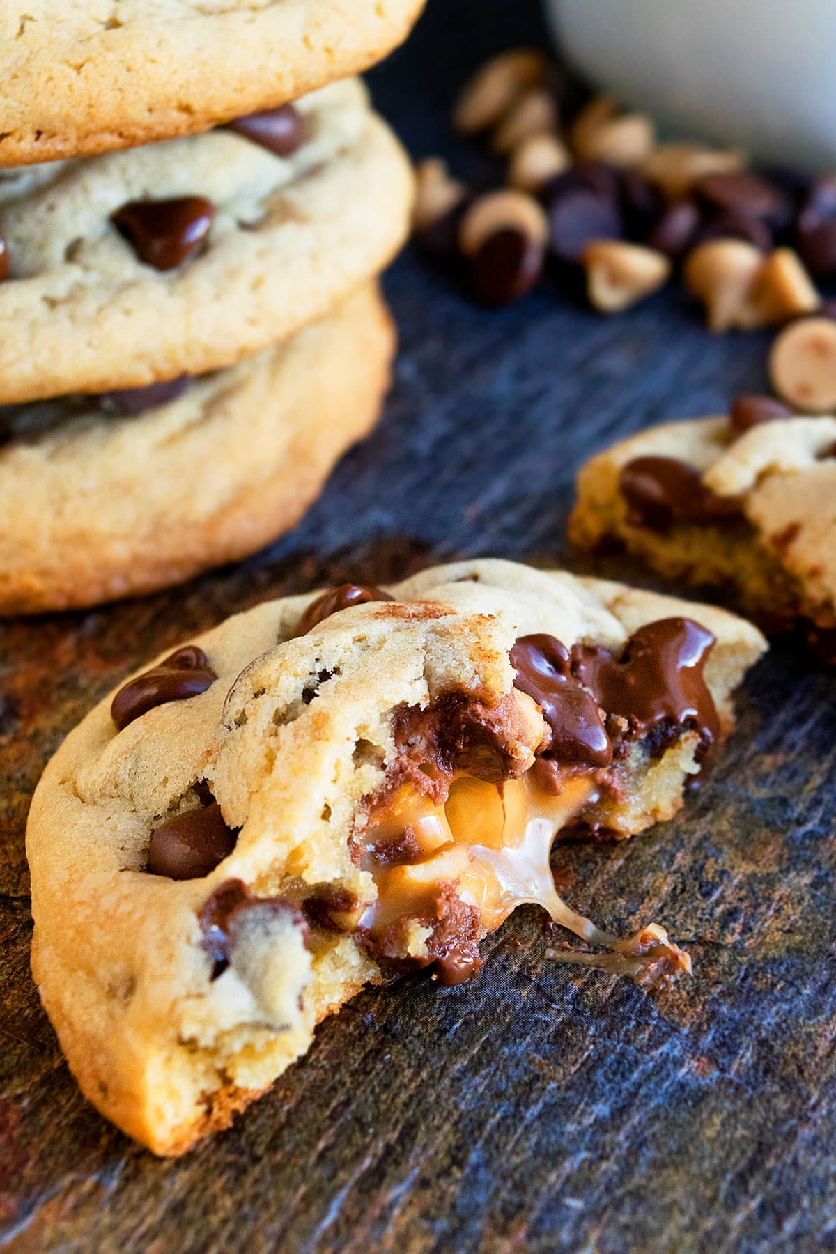 Easy Stuffed Salted Caramel Chocolate Chip Cookies That Are Partially Eaten on Rustic Background. 