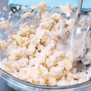 Butter and sugar being creamed in mixing bowl. 