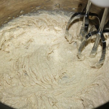 Butter, granulated sugar, brown sugar, egg, banana and vanilla being mixed in a large bowl. 