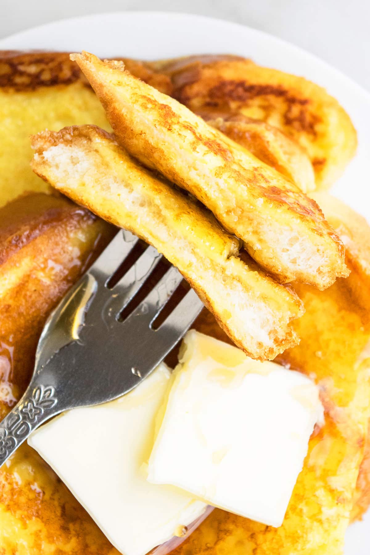 Closeup Shot of Fork Full of Christmas French Toast Breakfast on White Dish. 