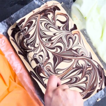 Chilled fudge being sliced with sharp knife. 