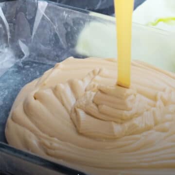 Fudge mixture being poured into lined pan. 