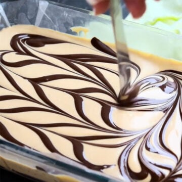 Melted chocolate being swirled on top of fudge batter. 