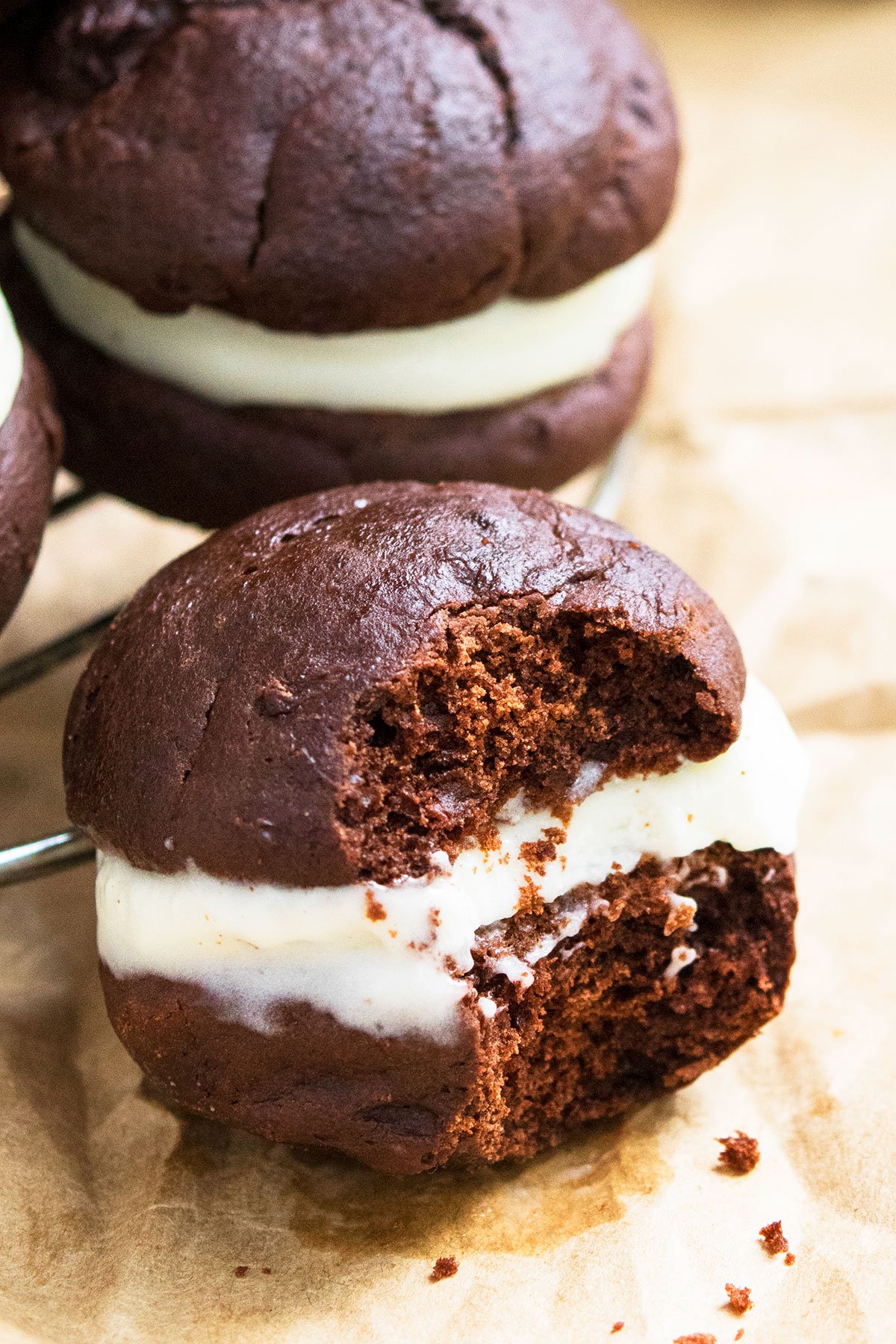 Partially Eaten Cake-Like Cookie Sandwich on Brown Parchment Paper. 