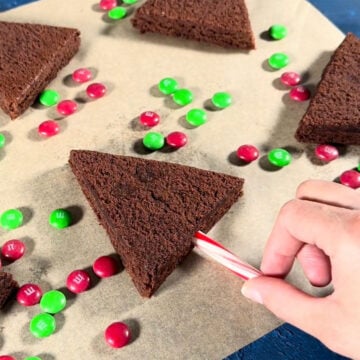 Candy cane being pushed into the base of the brownie. 