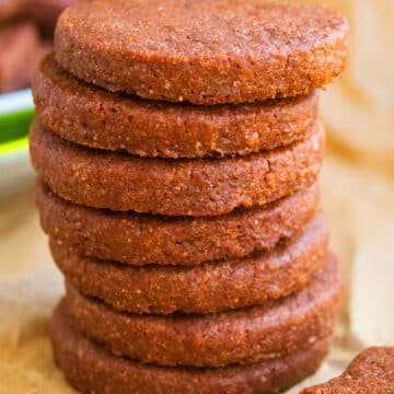 Stack of Easy Cut Out Chocolate Sugar Cookies on Sheet of Brown Parchment Paper.