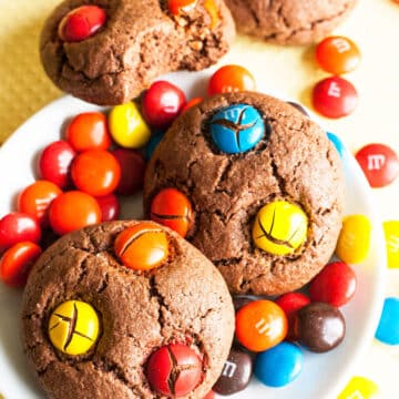 Easy Chocolate M&M Cookies With Cake Mix on White Dish and Yellow Background.