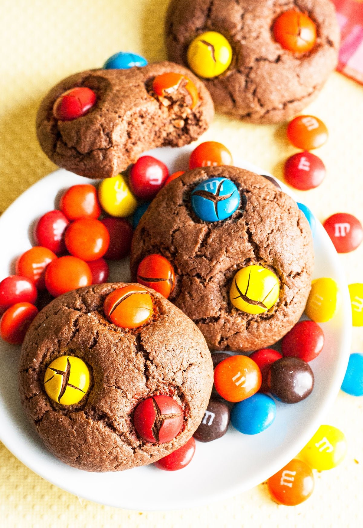 Easy Chocolate M&M Cookies With Cake Mix on White Dish and Yellow Background. 