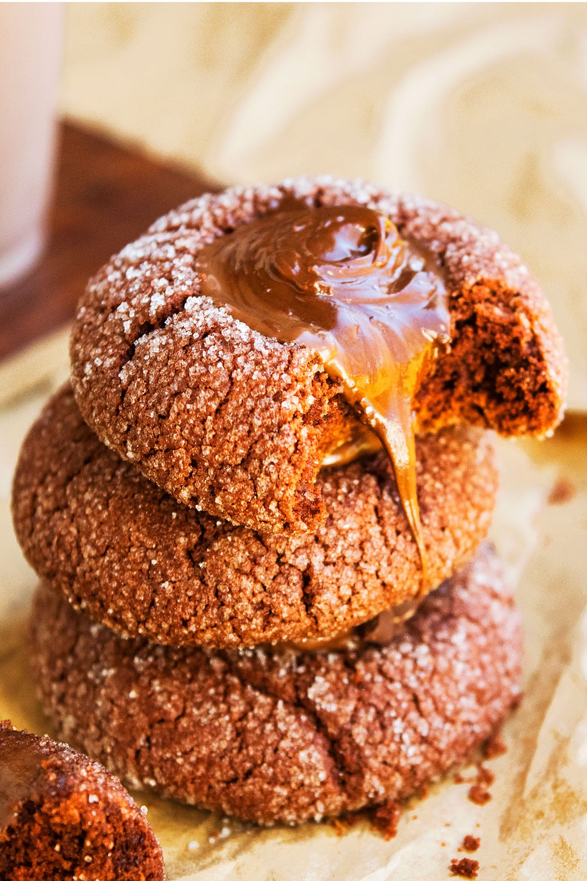 Stack of Chocolate Thumbprint Cookies With Ganache Filling on Brown Parchment Paper. 