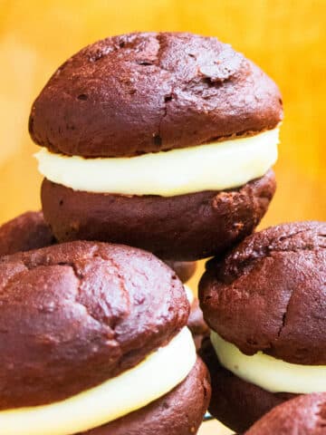 Stack of Easy Chocolate Whoopie Pies With Marshmallow Filling on Yellow Background.