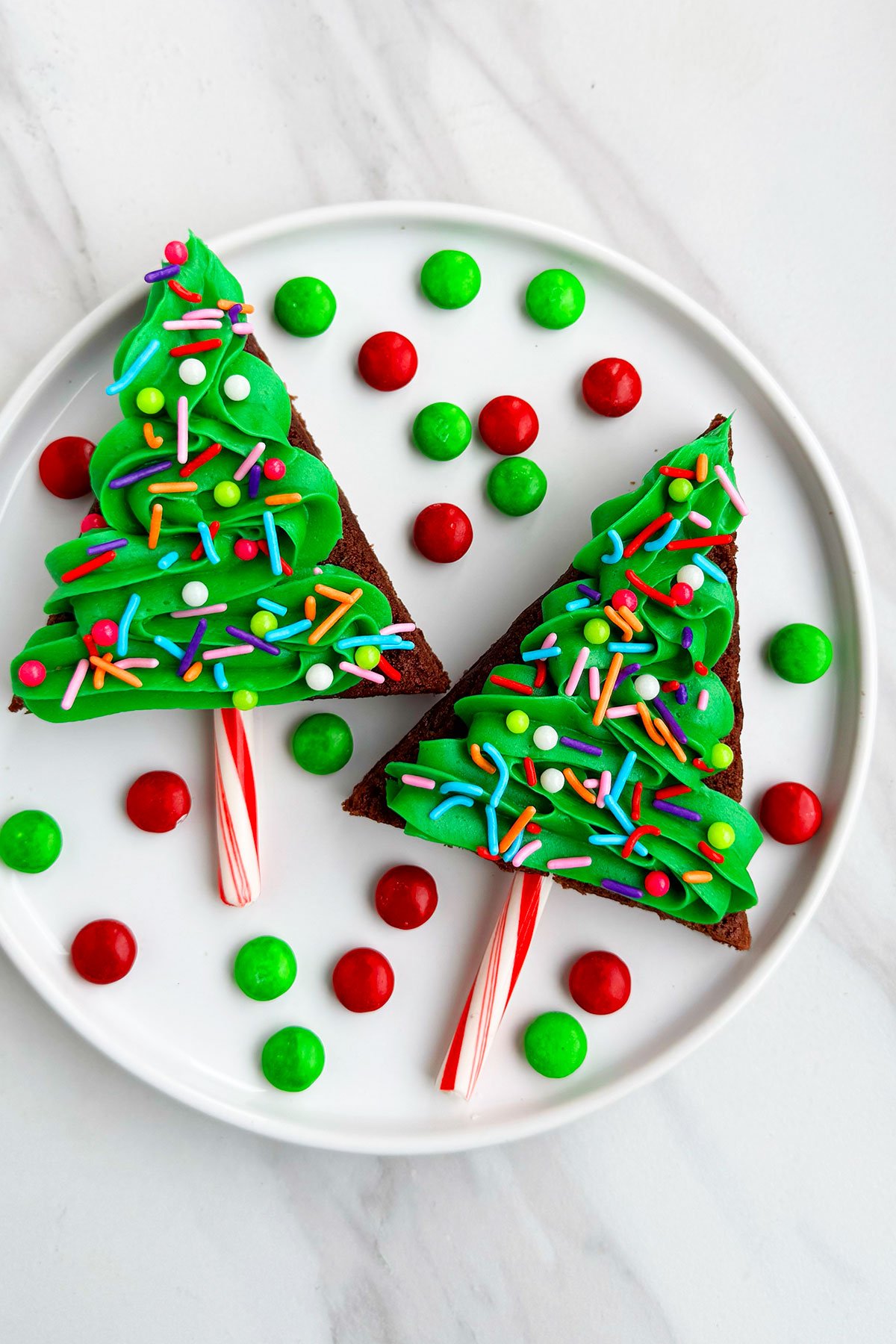 Easy Homemade Christmas Brownie Bites on White Dish With M&M Candies Scattered Around. 