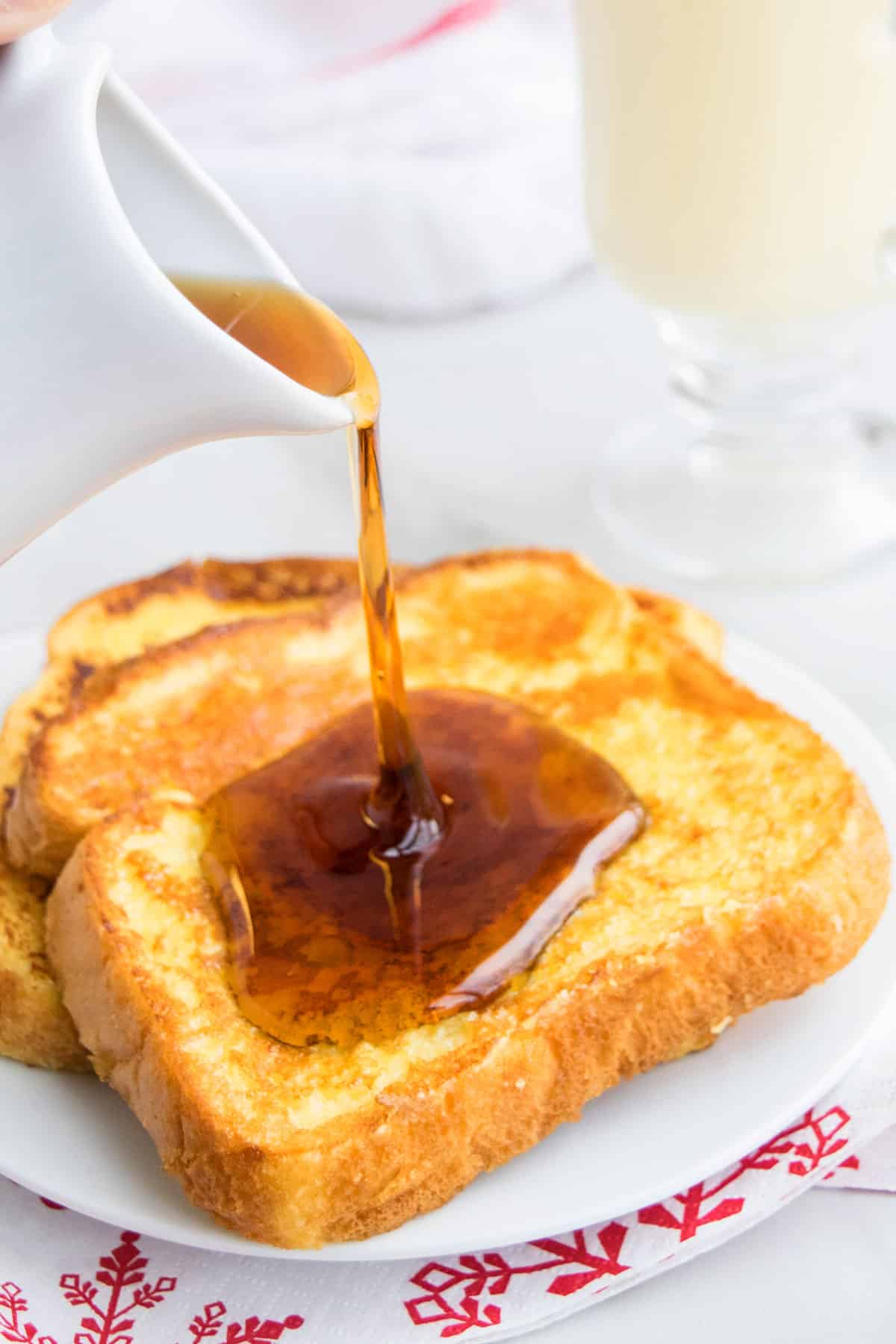 Syrup Being Drizzled on Top of French Toast in White Dish. 