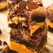 Stack of Easy Chocolate Caramel Brownies With Brownie Mix on Brown Parchment Paper.