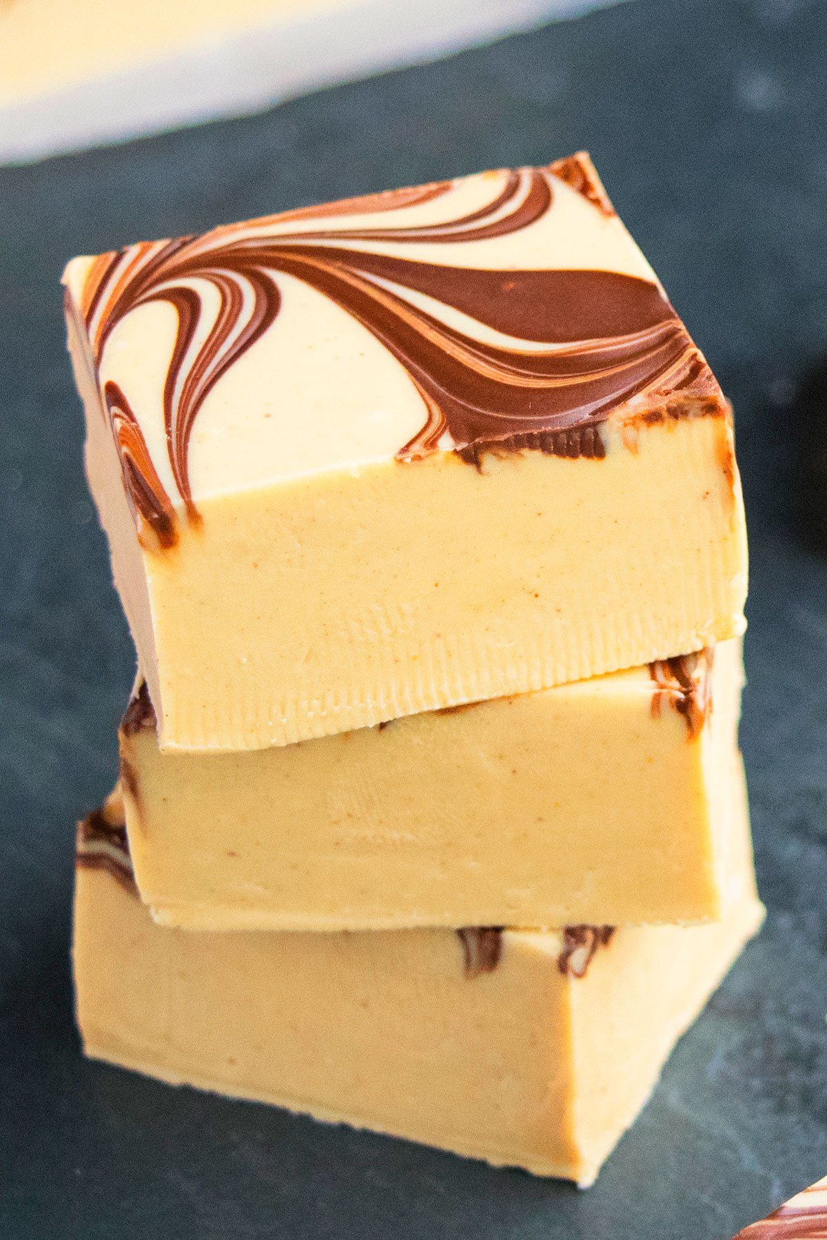 Stack of Easy Chocolate Peanut Butter Fudge on Dark Gray Background. 