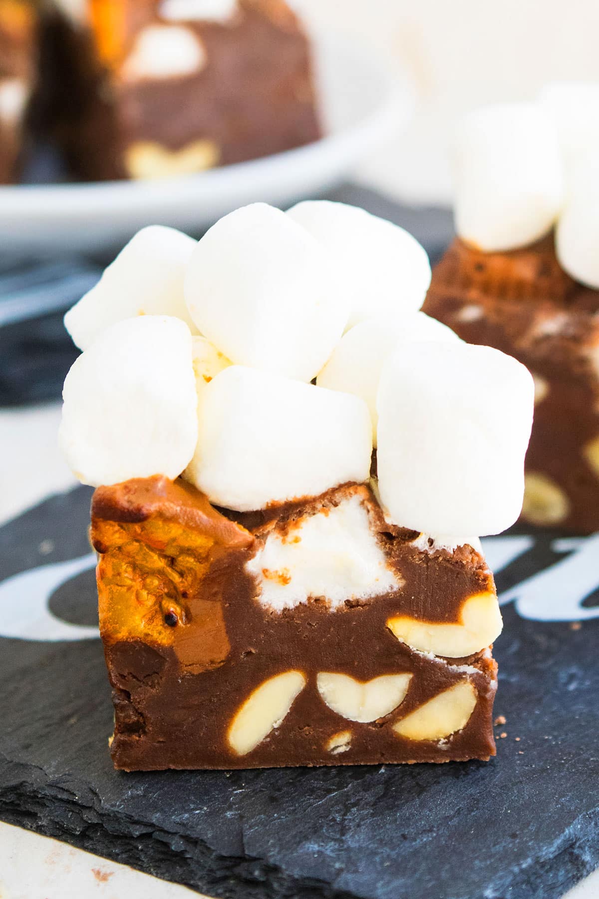 Closeup Shot of Homemade Fudge With Chocolate, Peanut and Marshmallows on Black Dish. 