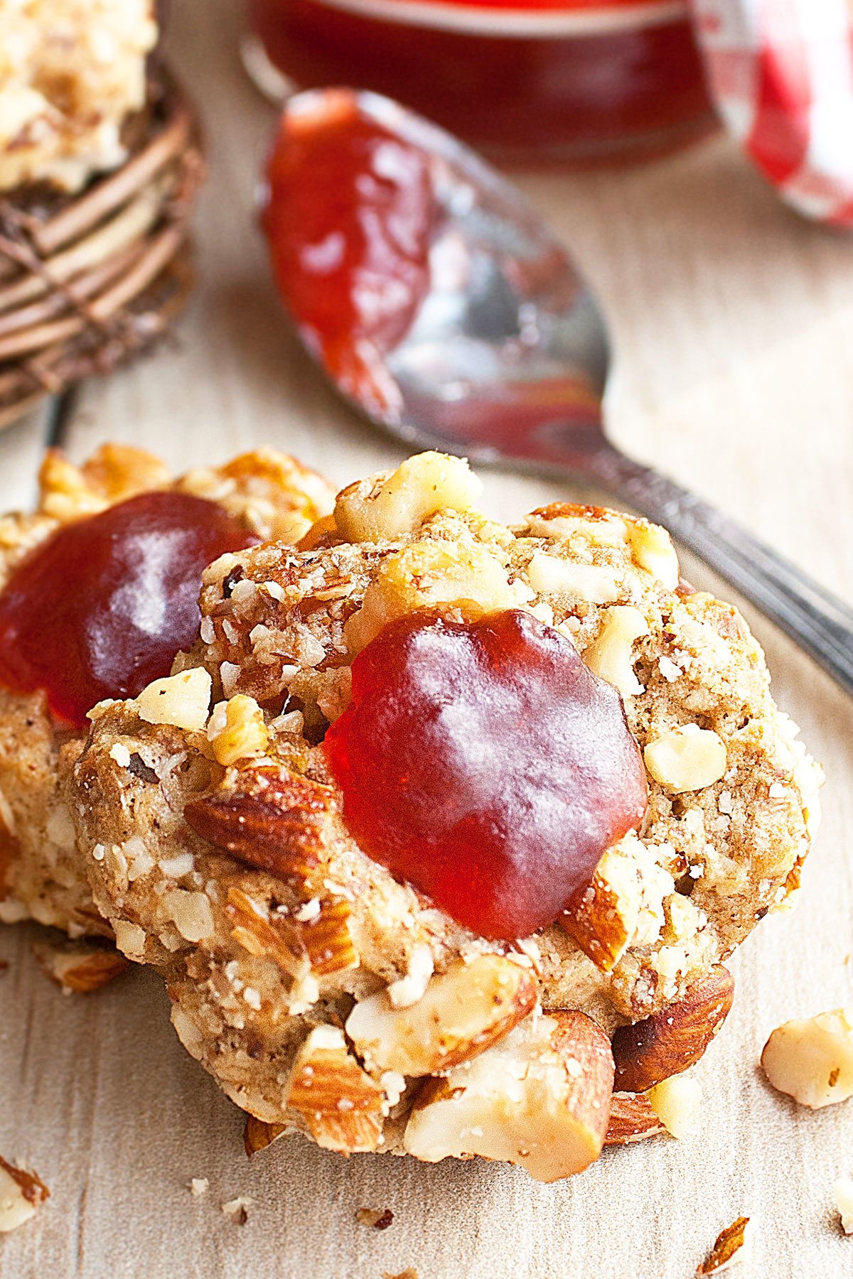 Closeup Shot of Thumbprint Cookies Filled With Strawberry Jam on Rustic Wood Background. 