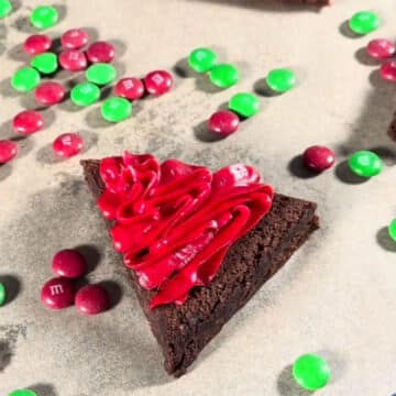 Red frosting swirls on triangle brownie. 