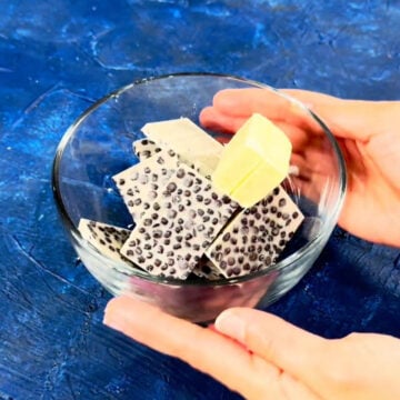 Cookies and cream candy bar pieces and butter in glass bowl. 