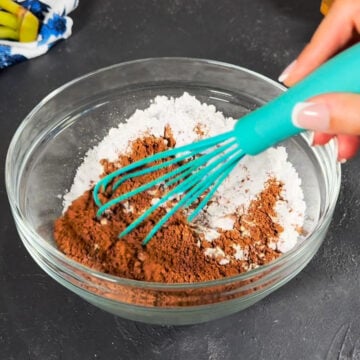 Cocoa powder and powdered sugar in glass bowl. 