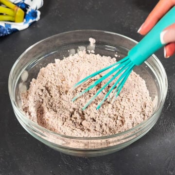 Cocoa powder and powdered sugar whisked together with turquoise whisk. 