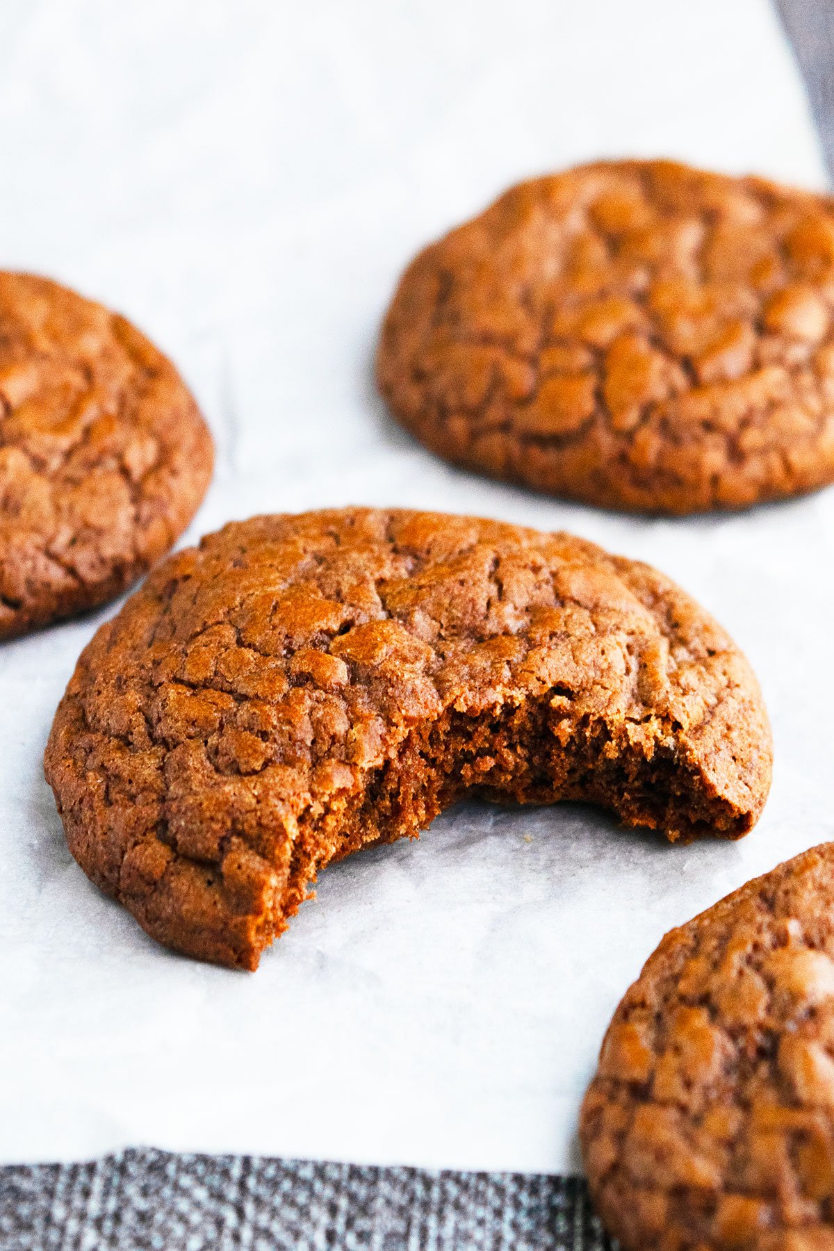 Partially Eaten Chocolate Cookie on Sheet of Parchment Paper.