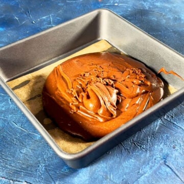 Brownie batter poured in lined baking pan. 