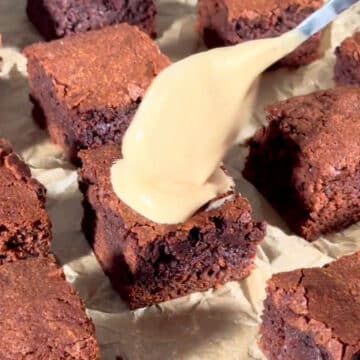 Slices of brownies being topped off with glaze. 