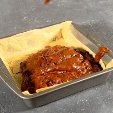 Brownie batter in lined baking pan. 