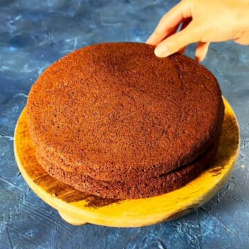 Second brownie layer being placed on top of icing.  