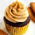 Easy Biscoff Cupcakes With Cookie Butter Frosting in Golden Liners on White Marble Background.
