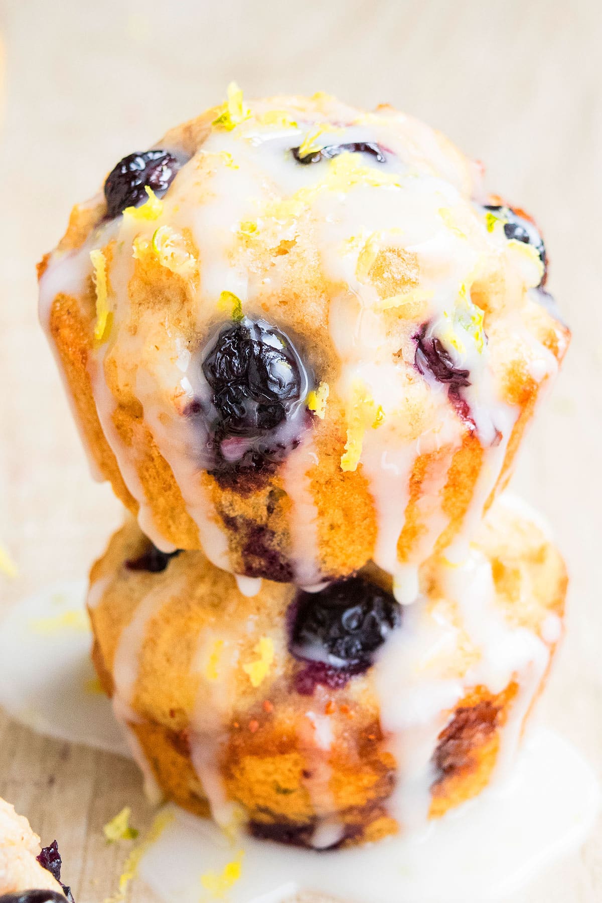 Stack of Glazed Muffins on Light Brown Background. 