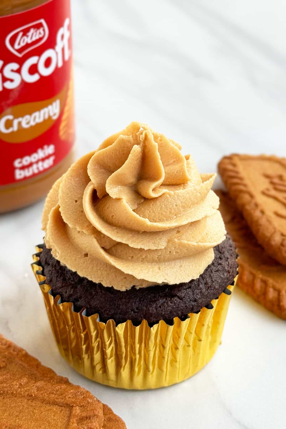 Easy Biscoff Cupcakes With Chocolate Cake Mix Box in Golden Liners on White Marble Background.