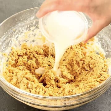 Milk being added to mixture in glass bowl. 