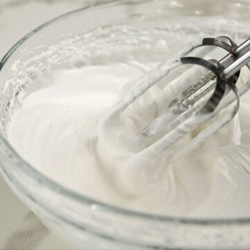 Meringue topping being whipped in glass bowl. 
