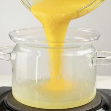Tempered egg yolks being added to lemon mixture. 