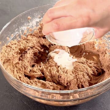 More milk added to glass bowl. 