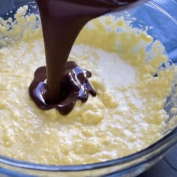 Pouring chocolate mixture into butter mixture. 