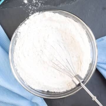 Flour and leavening agents whisked together in glass bowl. 