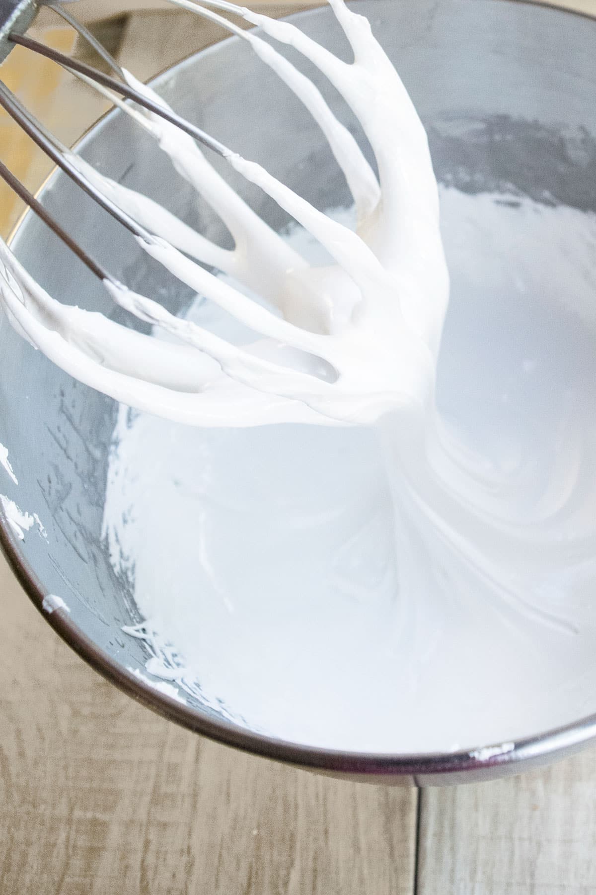 Fluffy White Frosting Without Butter on Whisk Over Bowl.  
