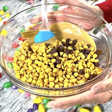 Chocolate chips, butterscotch chips and peanut butter in glass bowl. 