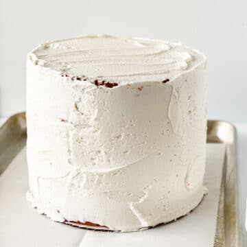 Three cake layers stacked and covered in white buttercream. 
