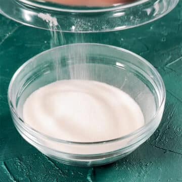 Granulated sugar being added to glass bowl.